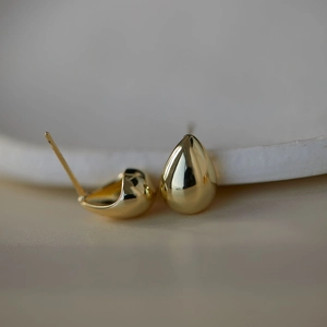 Boucles d'oreilles gouttes dorées polies avec une finition métallique lisse et épurée