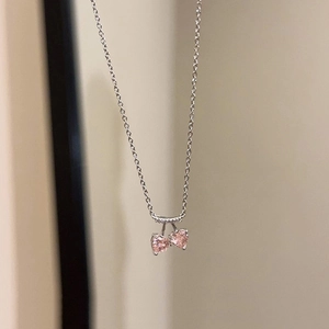 Détail du pendentif cerise en cristal rose sur une fine chaîne en argent poli