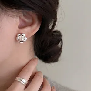 French camellia pearl stud earrings with silver petals on model for elegant styling