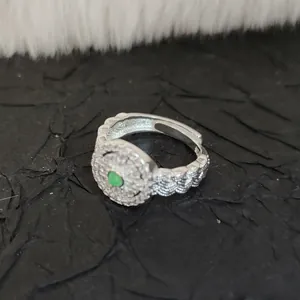 Close-up of vintage Hetian jade ring with lace woven silver band and sparkling crystals