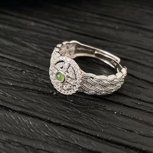 Macro shot of S925 sterling silver braided ring band with green jade and tiny diamonds
