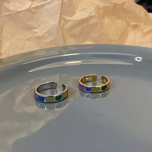 Colorful heart enamel open rings in gold and silver finish on a ceramic plate