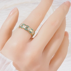 Macro view of French style green and pearl white lattice ring on model's hand
