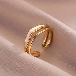 Detailed close-up of a triple-layered wave ring with elegant white enamel inlay