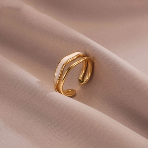 Modern double-layer gold wavy open ring with white enamel detail on beige satin