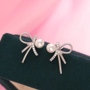 S925 sterling silver bow pearl earrings with sparkly crystals on a velvet box