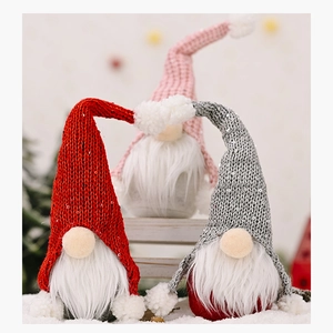Three plush Christmas gnomes with sequined hats on a snowy wooden display stand