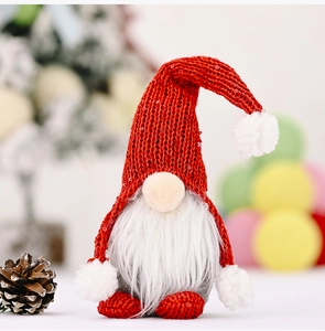 Detail eines roten gestrickten Weihnachtswichtels mit Pailletten und Kunstbart