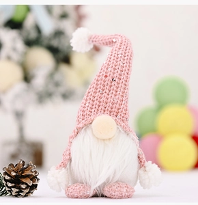 Nahaufnahme von rosa gestricktem Weihnachtswichtel mit Paillettenhut und weißem Bart