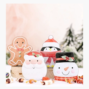 Detail of four festive Christmas tin boxes with gingerbread, Santa, penguin and snowman