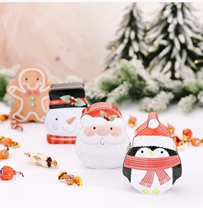 Close-up of four festive Christmas tin boxes with Santa, snowman and penguin characters