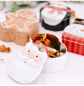 Detail of an open Christmas tin gift box filled with candy and embossed cartoon characters