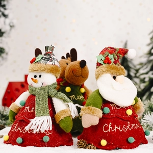 Detail of plush Christmas tree-shaped gift bags with snowman and reindeer embroidery