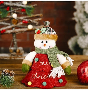 Detail of Christmas snowman plush decor featuring red ruffled dress and embroidery