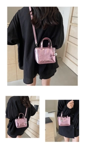 Detailed macro view of pink metallic patent leather handbag with silver sphere ornament