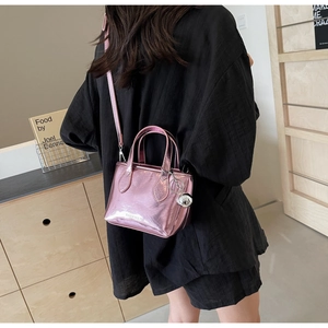 Detail of metallic pink mini bucket bag with silver ball charm and textured finish