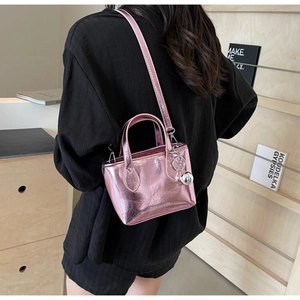 Rear view of a model wearing the pink metallic mini bucket bag with silver ball charm
