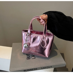 Detail of pink metallic mini tote with crinkled texture and silver sphere pendant
