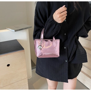 Detail of metallic purple mini bucket bag with silver ball charm and brand logo