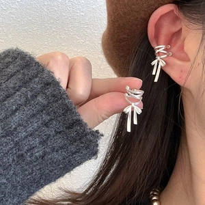 Elegant silver ribbon bow ear cuffs for women shown on a model in a stylish close-up view