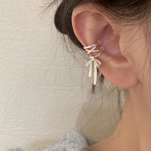 Detailed view of silver bow ribbon ear bone clip with elegant multi-layer wrap design