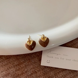 Macro detail of French vintage heart studs with brown enamel and gold metal clasp