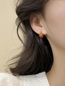 Detailed view of French vintage gold earrings with deep red heart charms on a model