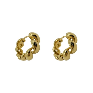 Chic twisted rope gold hoop earrings with polished metal texture on white background