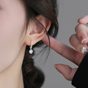 Minimalist silver twist hoop earrings featuring a blue heart-shaped moonstone pendant