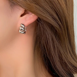 Polished silver twisted rope hoop earrings with a chunky braided design on model