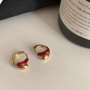 French vintage gold hoop earrings with red enamel droplet design in a lifestyle setting