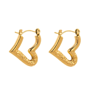 Detail of gold heart earrings showing hammered texture and secure clicker closure