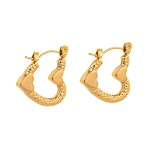 Macro detail of gold-plated heart hoop earrings featuring vintage hammered metal texture