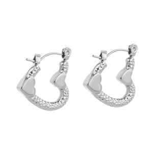 Macro detail of silver heart hoop earrings with hammered texture and polished finish