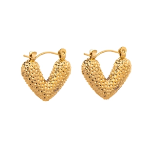 Detail of gold V-shaped leverback earrings with hammered metal texture and glossy finish