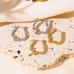 Polished gold and silver irregular wavy hoop earrings on a natural stone base