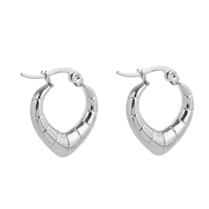 Macro detail of silver heart-shaped hoop earrings with textured spiral relief pattern