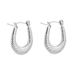 Macro detail of U-shaped silver hoop earrings with classic polished croissant texture