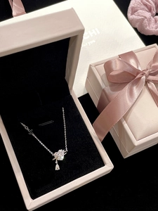 Detail of silver heart necklace with pear-shaped gemstone in a pink velvet jewelry box