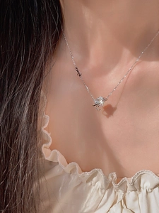 Close-up of silver orbit heart pendant necklace with zircon inlay on model neck