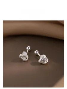 Détail de boucles d'oreilles nœud en argent avec fermoir à vis sur soie