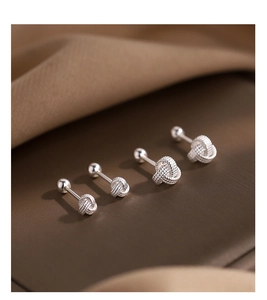 Gros plan de boucles d'oreilles nœud Ruyi en argent avec fermoir à vis sur tissu