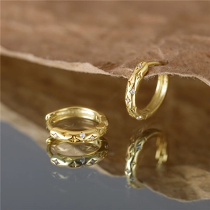 Elegant gold hoop earrings with star engraving and sparkling diamond zircon center