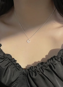 Collier cercle en argent minimaliste sur mannequin avec ombres élégantes de lumière
