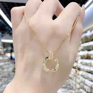 Dettaglio della collana con pendente geometrico dorato e micro-zirconi incastonati