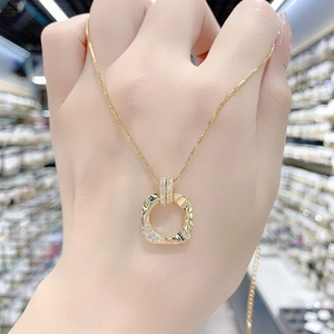 Dettaglio di una collana quadrata dorata con trama martellata e piccoli diamanti bianchi