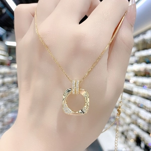 Dettaglio collana in oro 18K con ciondolo ad anello testurizzato e pavé di piccoli zirconi