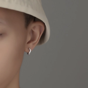 Close-up of minimalist S925 sterling silver frosted wavy hoop earring worn by a model
