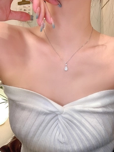 Dettaglio della collana con pendente in zircone a goccia su catena d'argento su modella