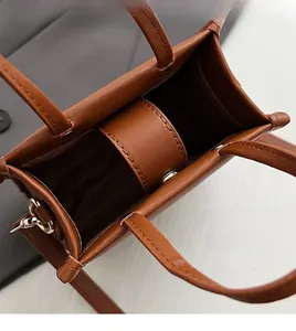 Detail of the interior compartment and gold hardware of the brown leather crossbody bag